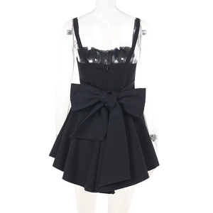 Détail de la mini-robe moulante noire ornée d'un grand nœud surdimensionné dans le dos