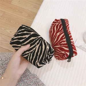 Detail of tiger and zebra print corduroy makeup bags with smooth black zippers