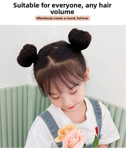 Detail showing two natural black round hair buns on a young girl for symmetric styling