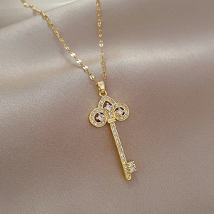 Luxurious gold crown key necklace with sparkling zircons on elegant beige silk