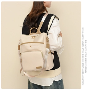 Rear view of model wearing a minimalist beige backpack with adjustable straps for travel