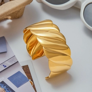 Modern gold-plated stainless steel striped open bangle with a textured croissant design