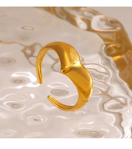 Macro shot of minimalist gold V-shaped open ring on a textured glass surface