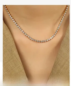Détail d'un collier tennis doré avec cristaux ronds porté sur un blazer kaki