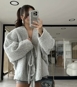 Detail of grey fuzzy knit cardigan with drawstring ties and soft plush texture