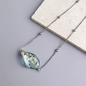 Detail of colorful waterdrop glass pendant with gold leaf foil on beaded chain