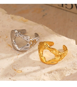 Detailed view of irregular hammered 18K gold and silver rings on a stone base