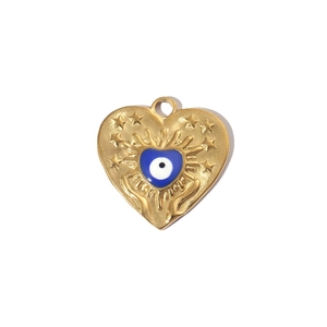 Macro view of gold heart pendant with blue evil eye and star engraving detail