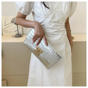 Silver crocodile embossed clutch bag featuring a prominent gold H-shaped metal buckle