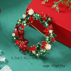 Detail of Christmas wreath brooch with red and green rhinestones and a red bow