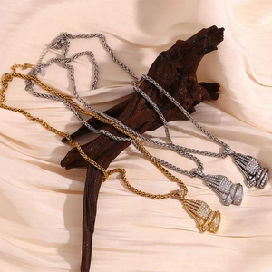 Detail of 18K gold and silver praying hands pendants with crystals on a twist chain