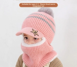 Detailaufnahme der rosa Strickmütze mit warmem Lammfellfutter und grauem Pompon-Detail