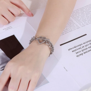 Silver multi-layer chain bracelet featuring a T-bar clasp and heart charm on a wrist