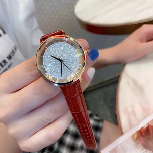 Detail of rose gold diamond-encrusted watch face with reddish brown crocodile leather strap