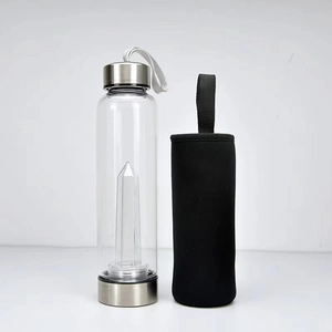 Detail of clear glass water bottle featuring a crystal stone pillar and black neoprene sleeve