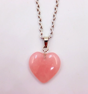 Close-up of a polished pink heart-shaped natural stone pendant on a silver metal chain
