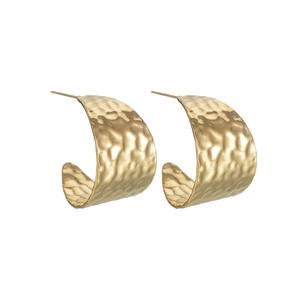 Macro detail of golden C-shaped earrings with unique hammered metal texture finish