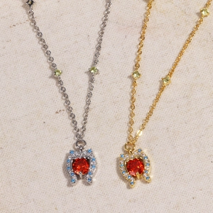 Ocean Heart necklaces in gold and silver finish with red gemstone heart pendants