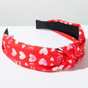 Detail of red knotted headband with pink hearts and LOVE letter prints on soft fabric