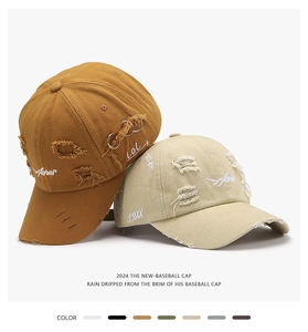 Close-up of distressed baseball cap with embroidery, ripped texture and metal ring detail