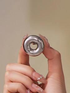 Macro shot of polished silver stainless steel hollow ring with mirror finish texture
