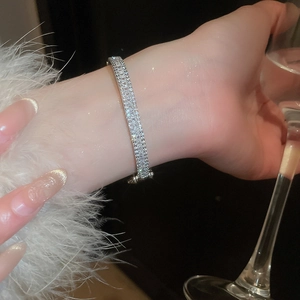 Macro view of silver rectangular zircon bangle with multi-row pavé setting on wrist