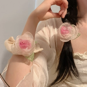 Romantic pink organza rose hair tie and bracelet set shown on a braided hair tail