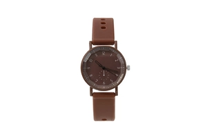 Macro detail of brown silicone strap and multi-faceted glass on women's quartz watch