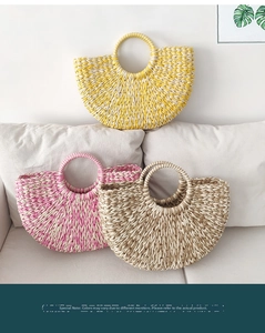 Detail of three handmade straw woven tote bags in yellow, pink and beige on a sofa