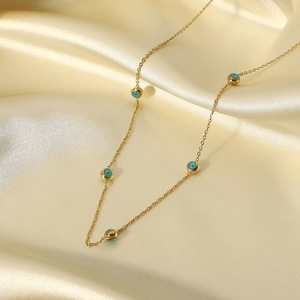 Detailed view of 18K gold plated stainless steel necklace with five blue evil eye beads