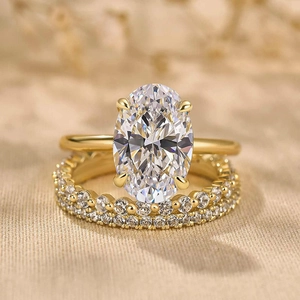 Detailaufnahme des vergoldeten Ring-Sets mit ovalem Edelstein und glitzernden Akzenten