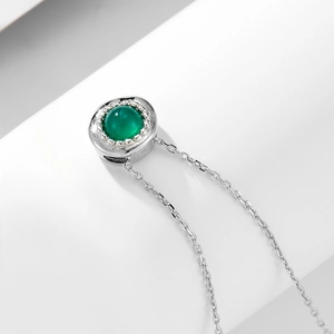 Detailed macro view of S925 silver necklace with a round green agate pendant on white backdrop