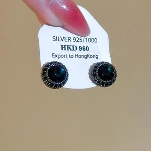 Macro shot of S925 silver stud earrings with vintage faceted dark gemstone and beadwork