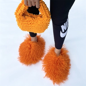 Detail of bright orange plush handbag and matching fuzzy slippers in vibrant candy color
