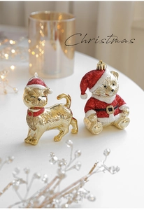 Close-up of golden cat and red glitter bear Christmas ornaments with warm festive lighting