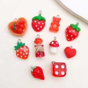 Macro shot of red resin charms including strawberry and bear for DIY crafts