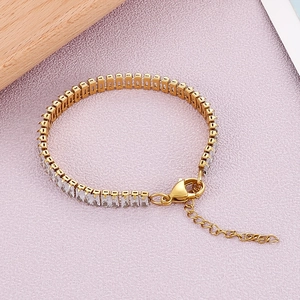 Détail d'un bracelet doré en acier inoxydable avec zircon carré et fermoir mousqueton