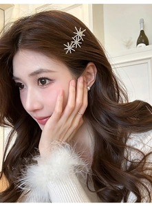 Close-up of sparkling star-shaped rhinestone hair clips on wavy brown hair