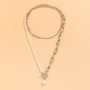 Detail of layered silver chain necklace with faux pearls and an OT toggle clasp design