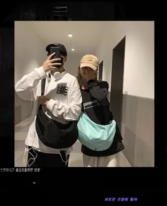Nylon crescent crossbody bags shown in black and mint green on male and female models