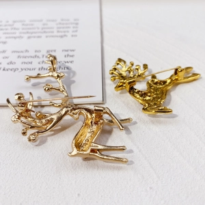 Detail of golden reindeer brooch back with secure pin clasp and textured metal surface