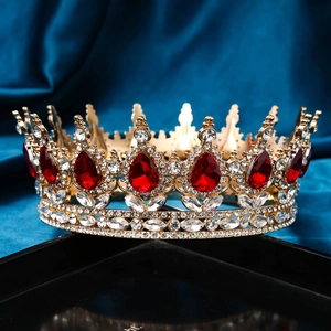 Detailed macro view of luxury gold bridal crown with red teardrop gems and clear rhinestones