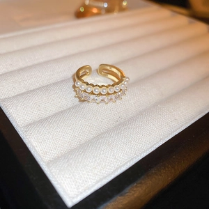 Detail of gold-plated open ring with white pearls and rectangular cubic zirconia stones