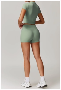 Detail of high-waist sage green yoga shorts and crop top made of high-stretch fabric