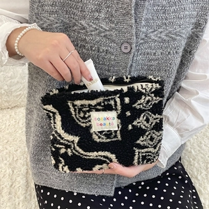 Detail of putting luxury cream into a plush polka dot cosmetic bag with zipper