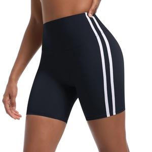 Detail of high-waist black biker shorts with white side stripes and elastic fabric