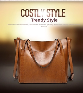 Detailed view of brown oil-wax leather texture and front pocket on large tote bag