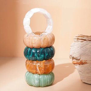 Detail view of five marble texture acrylic stretch bracelets in earthy assorted colors