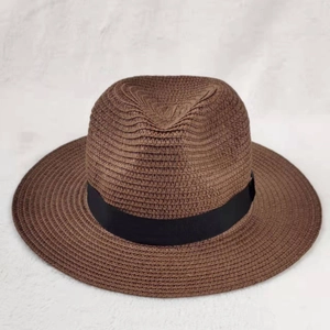 Classic brown straw sun hat with broad black ribbon trim for summer outdoor beach travel