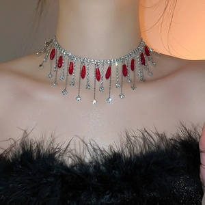 Detailed view of luxury silver crystal choker with red teardrop tassels on model